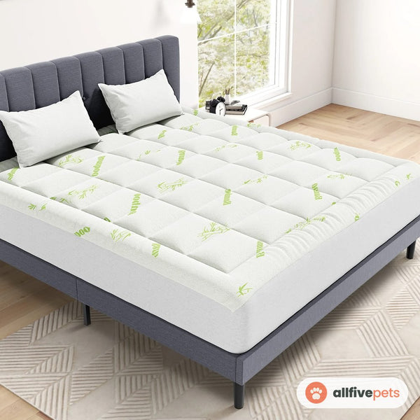 The quilted white topper fitted on a bed
