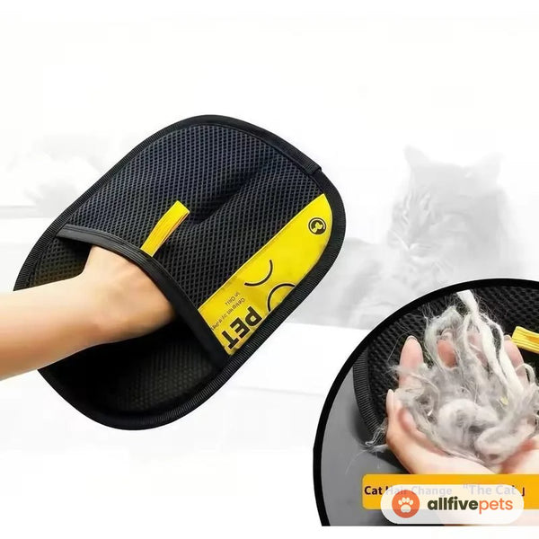 A hand wearing the black grooming mitt, beside a clump of collected cat hair