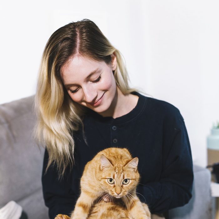 A customer sitting with her ginger cat on her lap